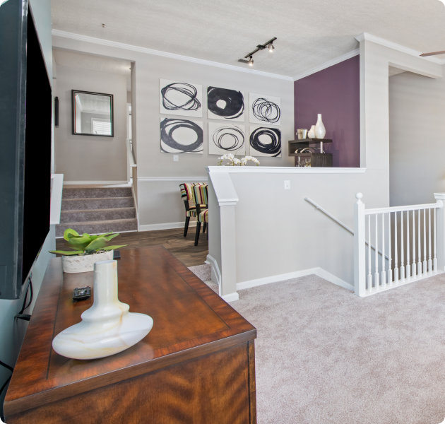 Open-concept living area with wooden dresser and stairs next to dining area at MAA Oglethorpe luxury apartments in Atlanta, GA