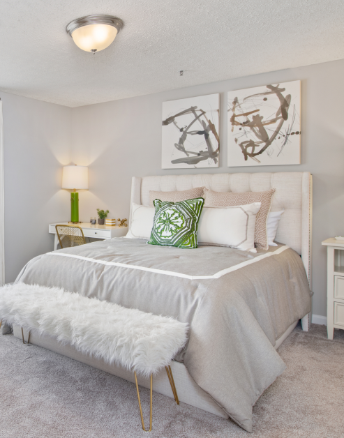 Cozy model bedroom with natural tone bedding, accent pillows and wall art at MAA Oglethorpe luxury apartments in Atlanta, GA