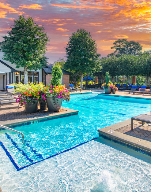 Serene swimming pool surrounded by lush greenery and potted flowers at MAA Oglethorpe luxury apartments in Atlanta, GA