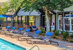 Poolside lounge chairs with pillow tops next to clubhouse at MAA Oglethorpe luxury apartments in Atlanta, GA