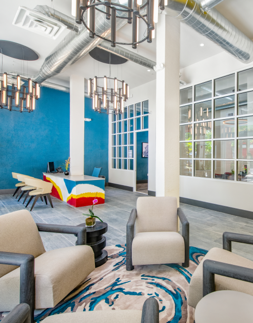Community clubhouse with colorful décor, modern furniture and light fixtures at MAA Piedmont Park luxury apartments in Atlanta, GA