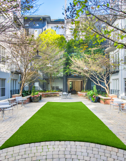 Lush grassy courtyard common area with trees at MAA Piedmont Park luxury apartments in Atlanta, GA