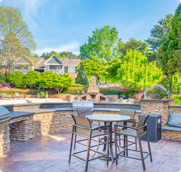 Outdoor grill station patio areas with tables and chairs at MAA Pleasant Hill luxury apartments in Duluth, GA