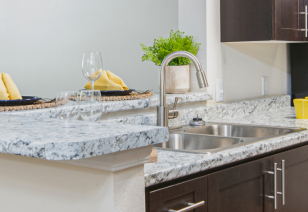 Modern kitchen with light grey marble granite countertops and stainless steel sink at MAA River Oaks luxury apartments in Duluth, GA