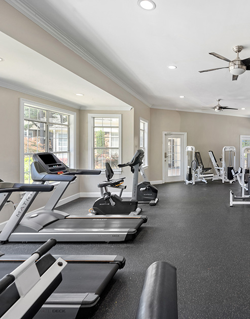 State-of-the-art fitness center with treadmill stations next to window views at MAA River Place luxury apartments in Duluth, GA