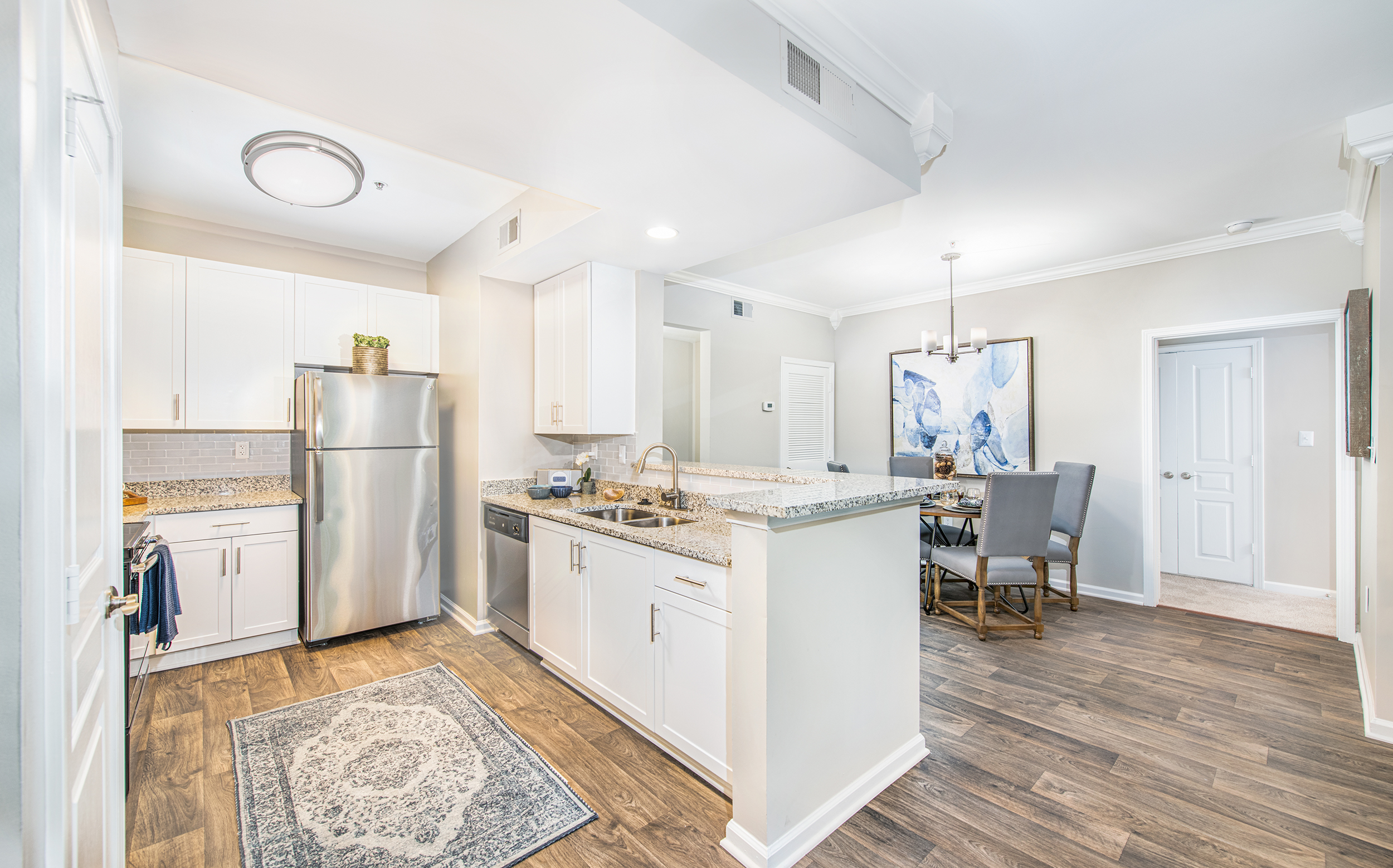 Open kitchen with granite countertops next to dining area at MAA Riverside luxury apartments in Atlanta, GA