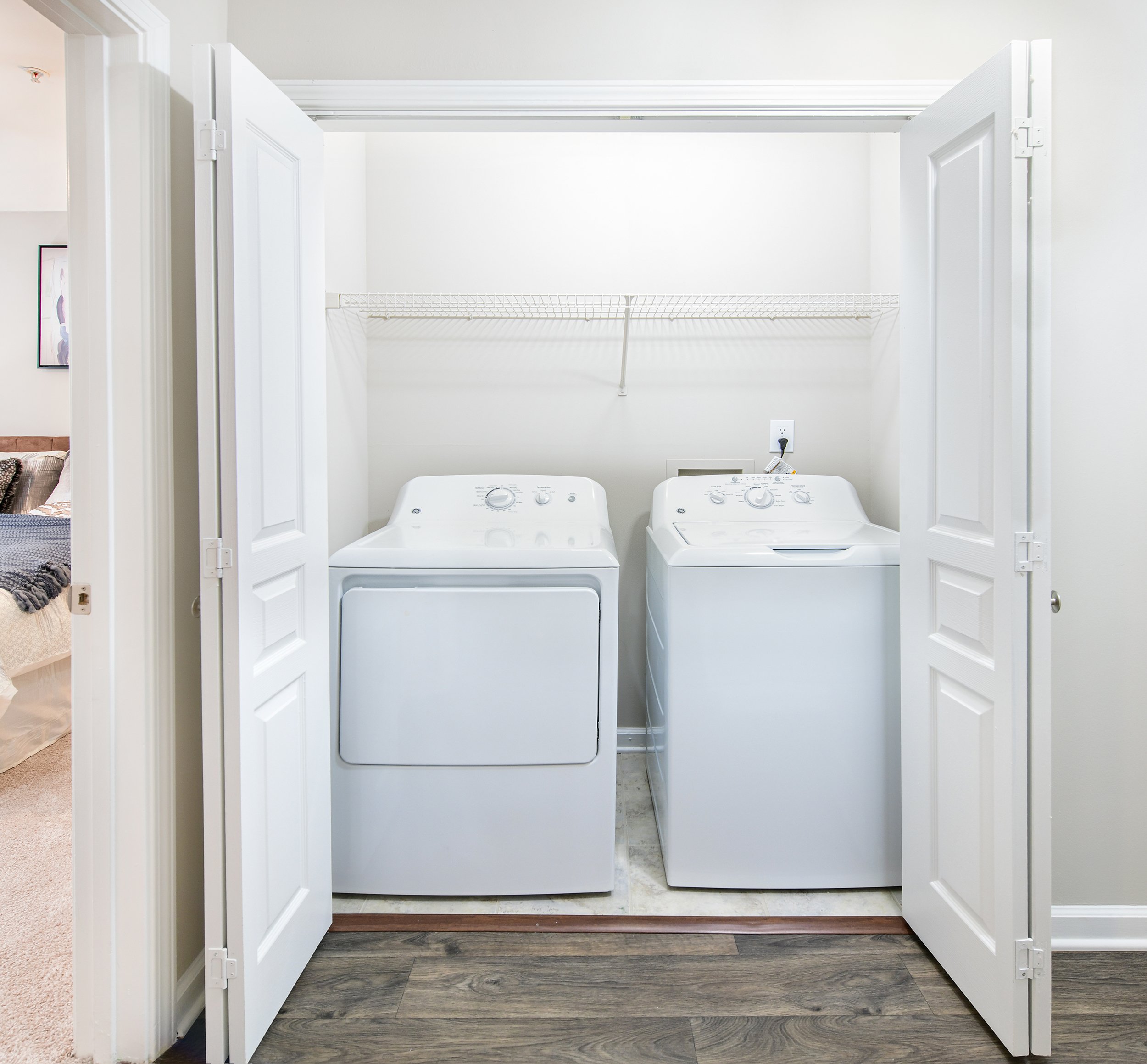 Laundry room with full sized washer/dryer and accordion doors at MAA Riverside luxury apartments in Atlanta, GA
