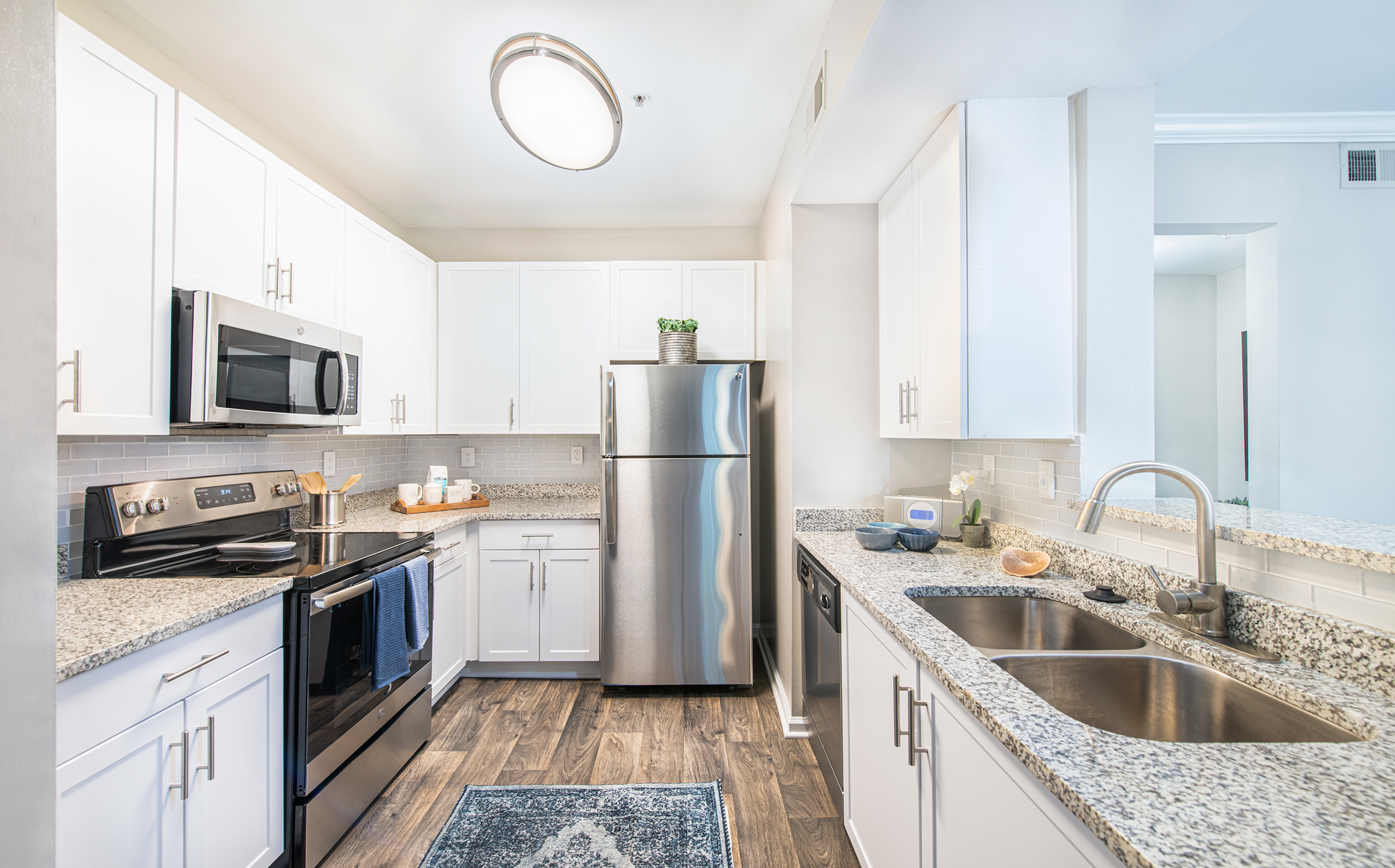 Modern kitchen with white cabinets and stainless steel appliances at MAA Riverside luxury apartments in Atlanta, GA