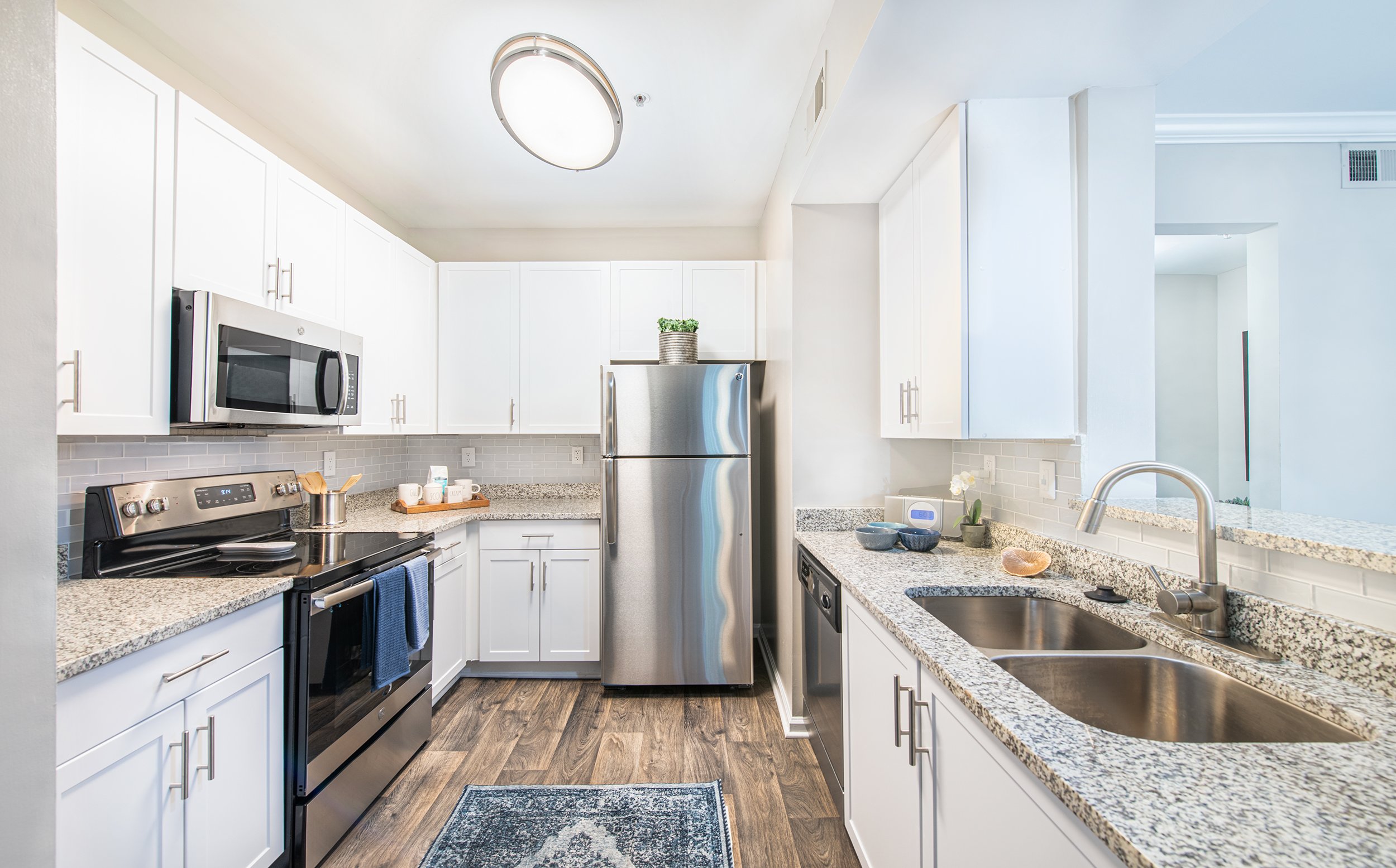 Modern kitchen with white cabinets and stainless steel appliances at MAA Riverside luxury apartments in Atlanta, GA