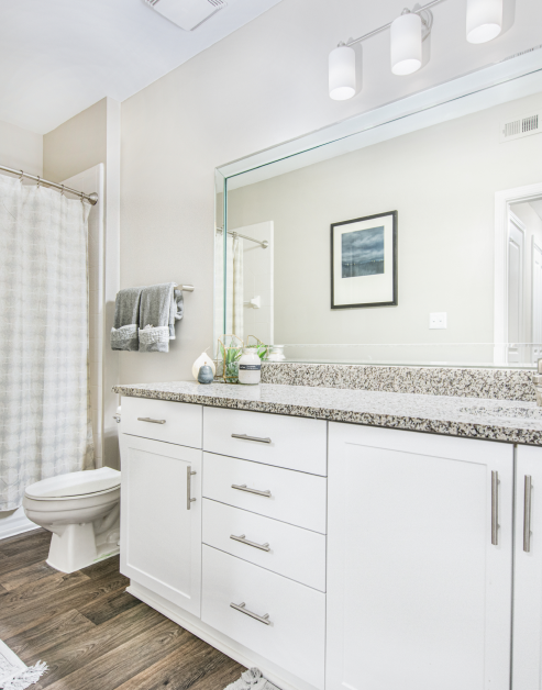 Pristine white bathroom with granite countertops at MAA Riverside luxury apartments in Atlanta, GA