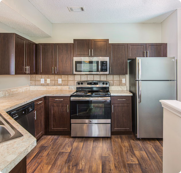 Apartment modern kitchen with dark brown cabinets, upgraded appliances and wood floors at MAA Shiloh luxury apartments in Kennesaw, GA