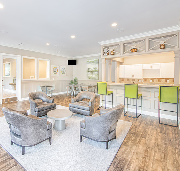 Community clubhouse with modern white décor including a sitting area and bar top kitchen area at MAA Shiloh luxury apartments in Kennesaw, GA