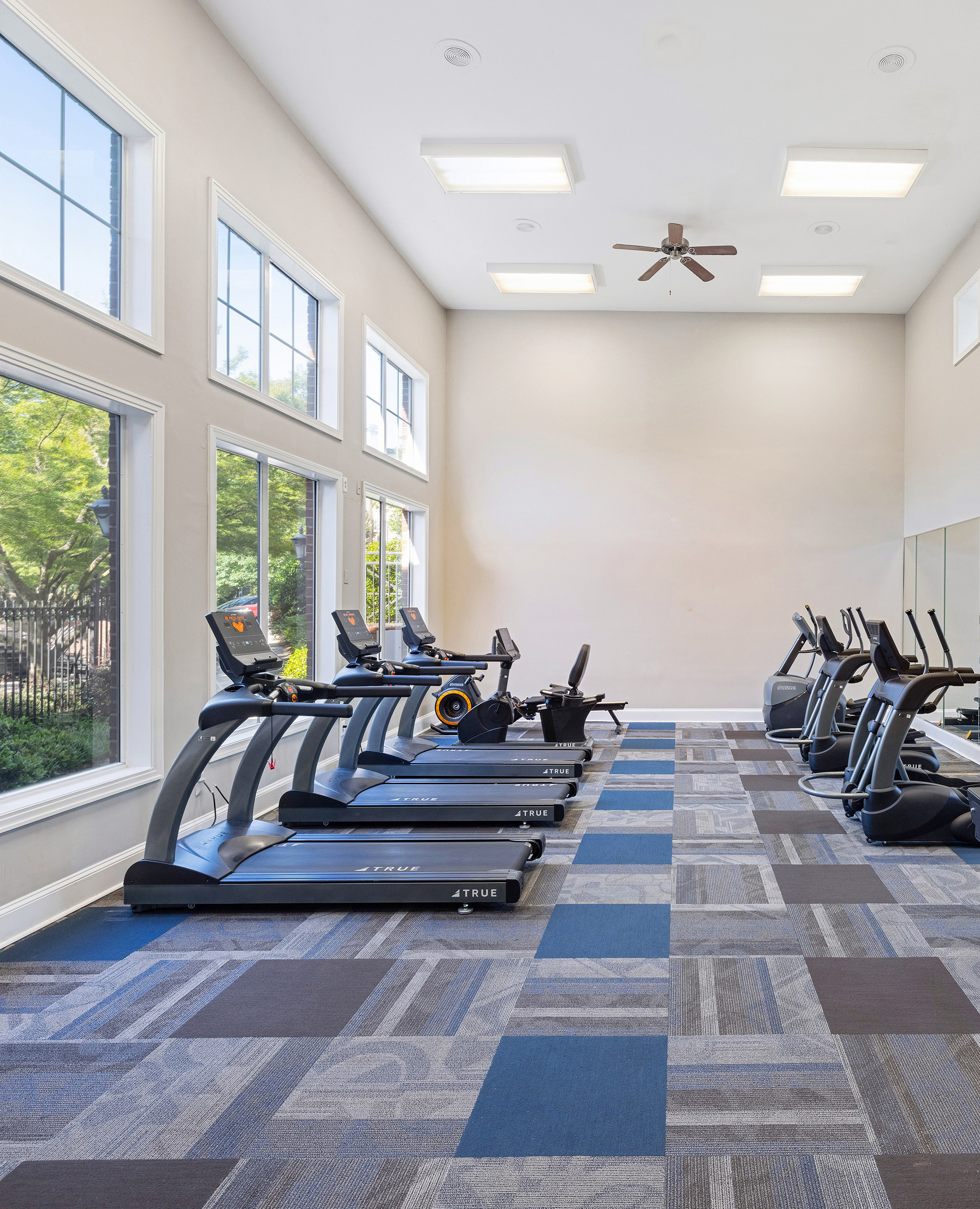 State-of-the-art fitness center with treadmill stations next to picture window views at MAA Shiloh luxury apartments in Kennesaw, GA