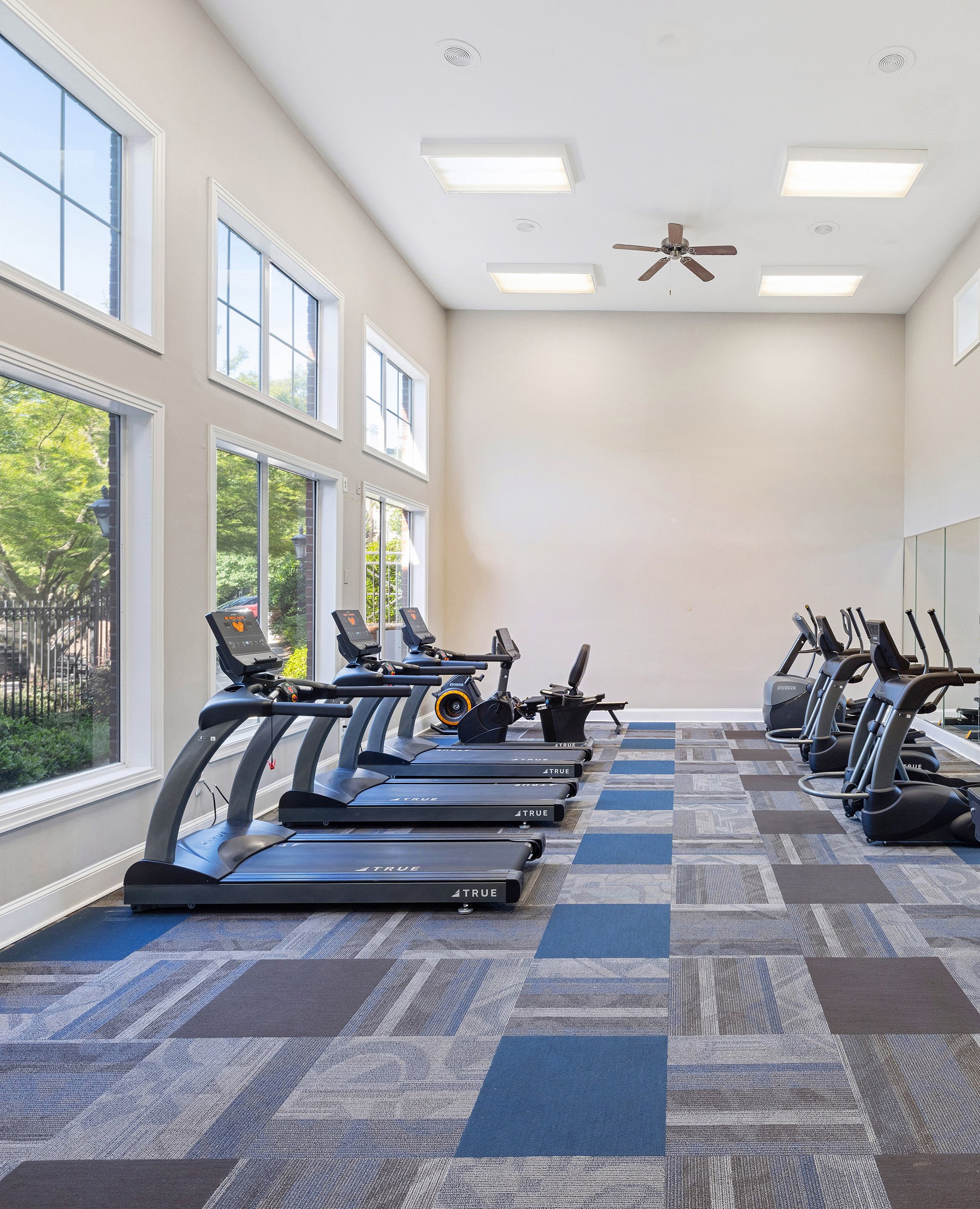 State-of-the-art fitness center with treadmill stations next to picture window views at MAA Shiloh luxury apartments in Kennesaw, GA