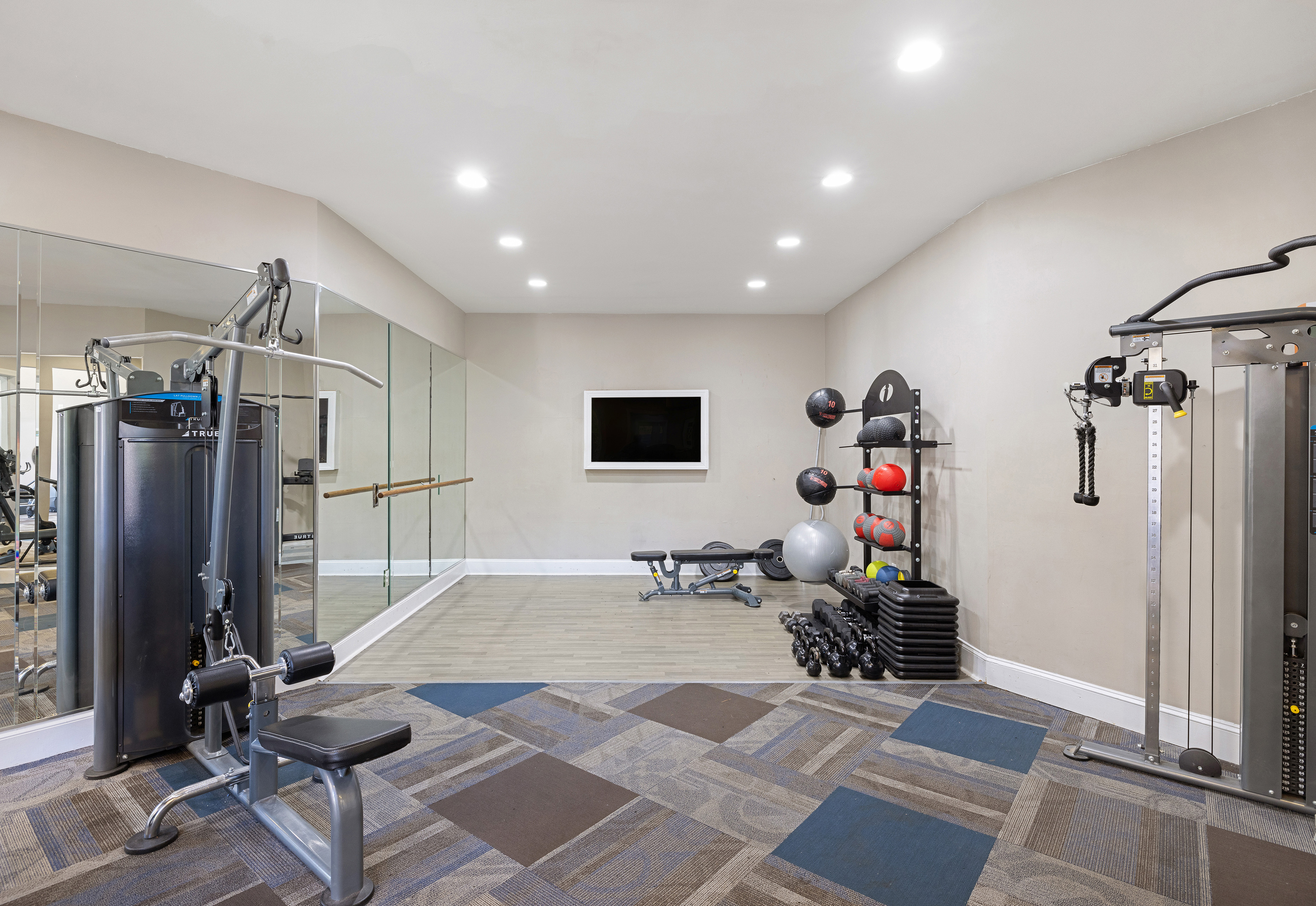 Fitness center studio space with mirrored walls and exercise equipment racks at MAA Shiloh luxury apartments in Kennesaw, GA