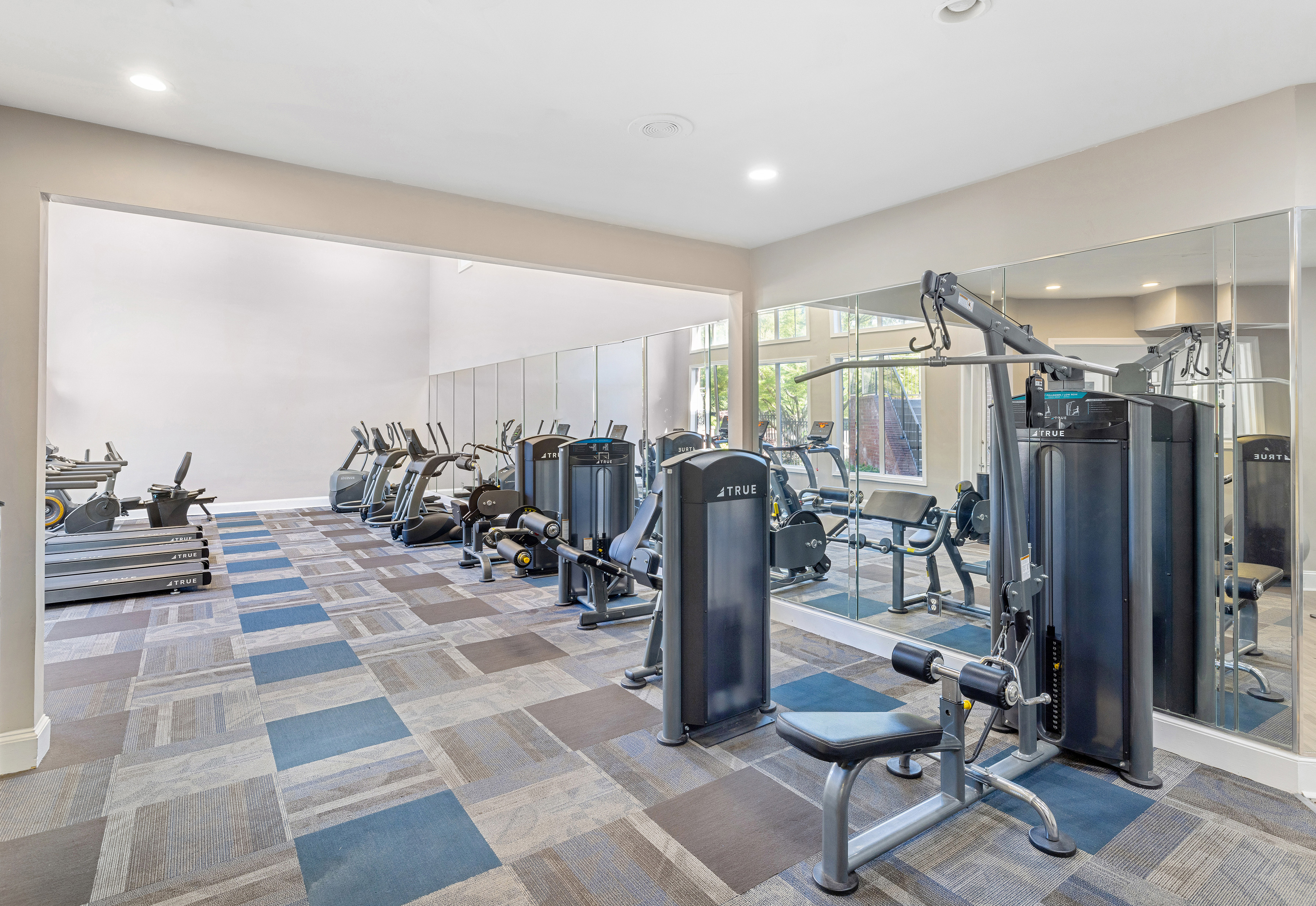 Carpeted fitness center with weight machine stations at MAA Shiloh luxury apartments in Kennesaw, GA