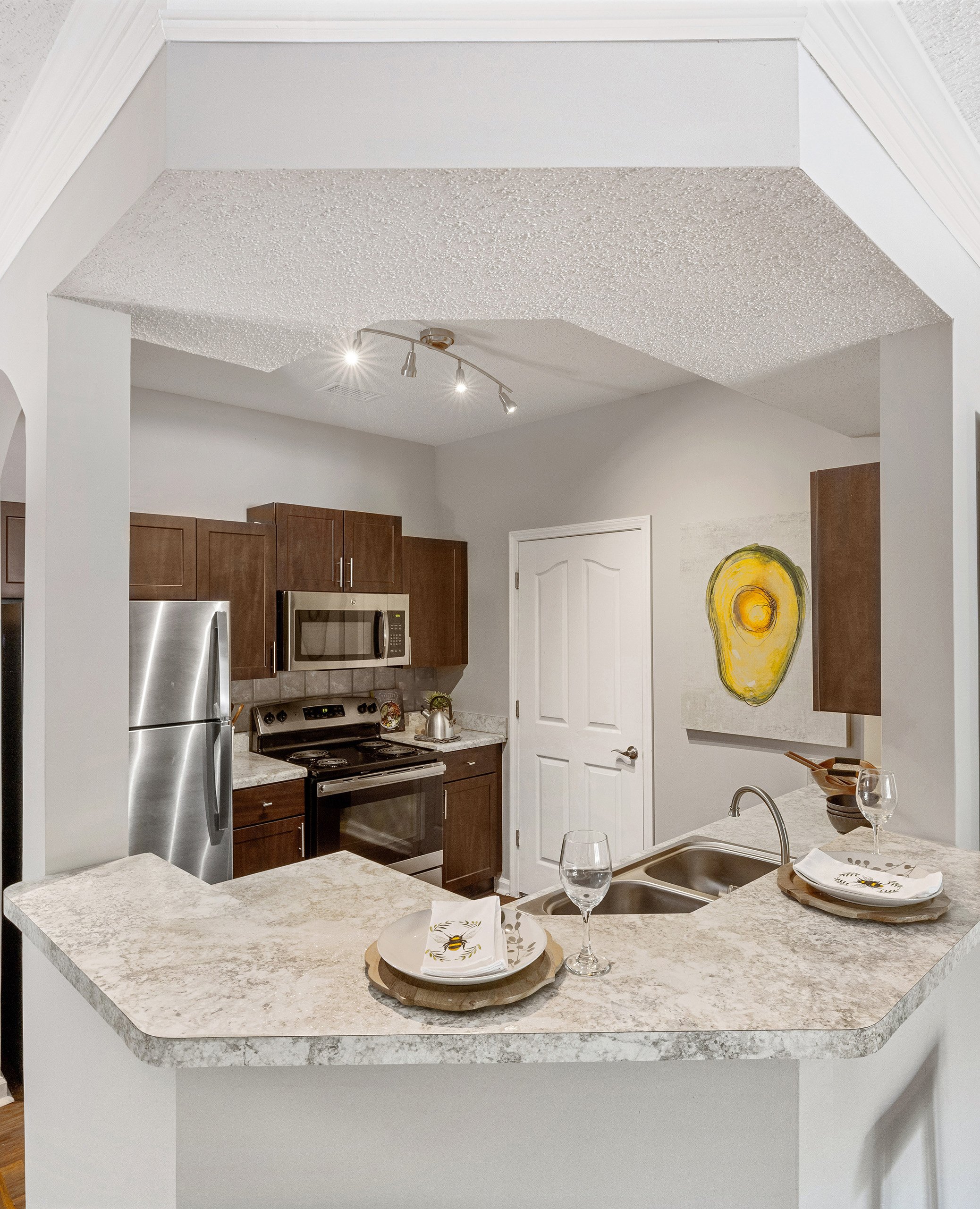 Modern kitchen with brown cabinets and upgraded appliances at MAA Shiloh luxury apartments in Kennesaw, GA