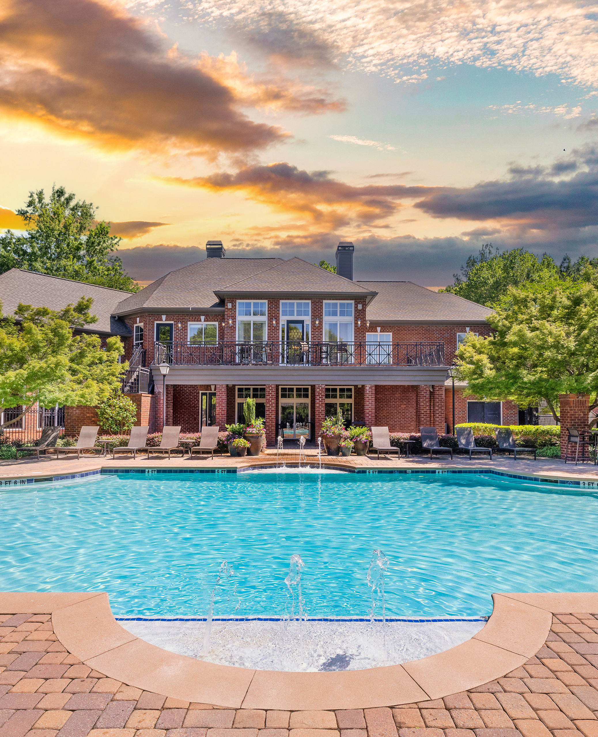 Swimming pool with lounge chairs in front of two-story clubhouse at MAA Shiloh luxury apartments in Kennesaw, GA