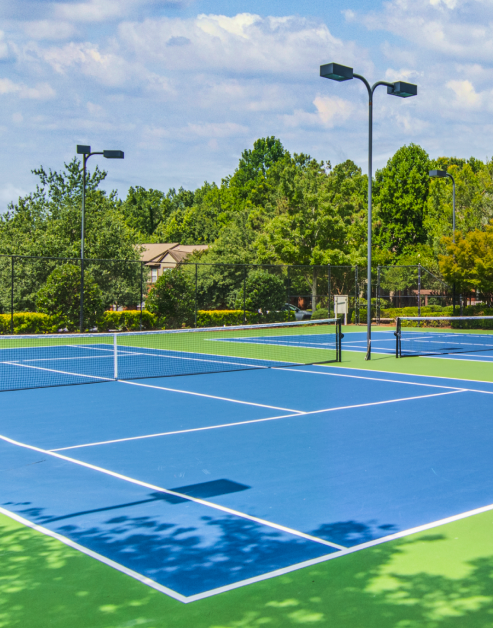 Tennis courts surrounded by trees at MAA Shiloh luxury apartments in Kennesaw, GA