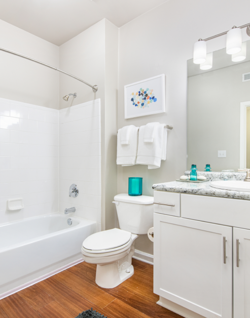 Upscale bathroom with hard wood floors, white cabinets and large bathtub/shower at MAA Spring luxury apartments in Smyrna, GA