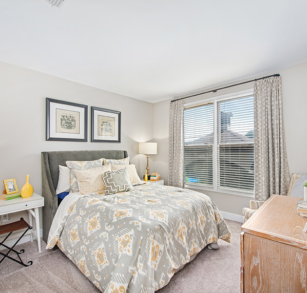 Light décor bedroom with night stands, full-size bed and tan dresser at MAA West Village luxury apartments in Smyrna, GA