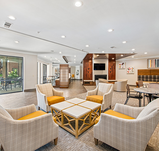Community clubhouse with spacious lounge areas with sofas and coffee tables at MAA West Village luxury apartments in Smyrna, GA