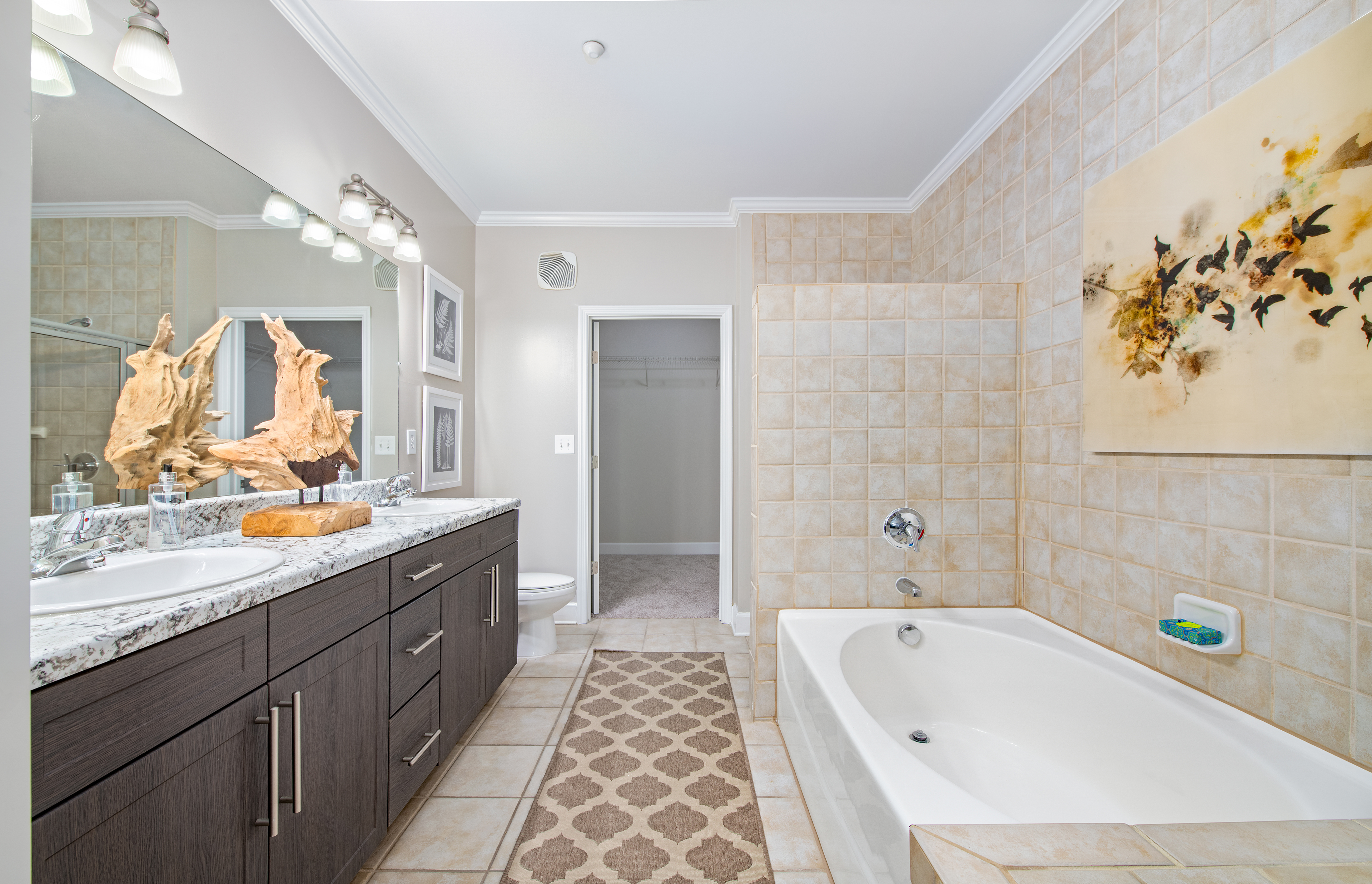 Spacious bathroom with dark cabinets, granite countertop and shower at MAA West Village luxury apartments in Smyrna, GA