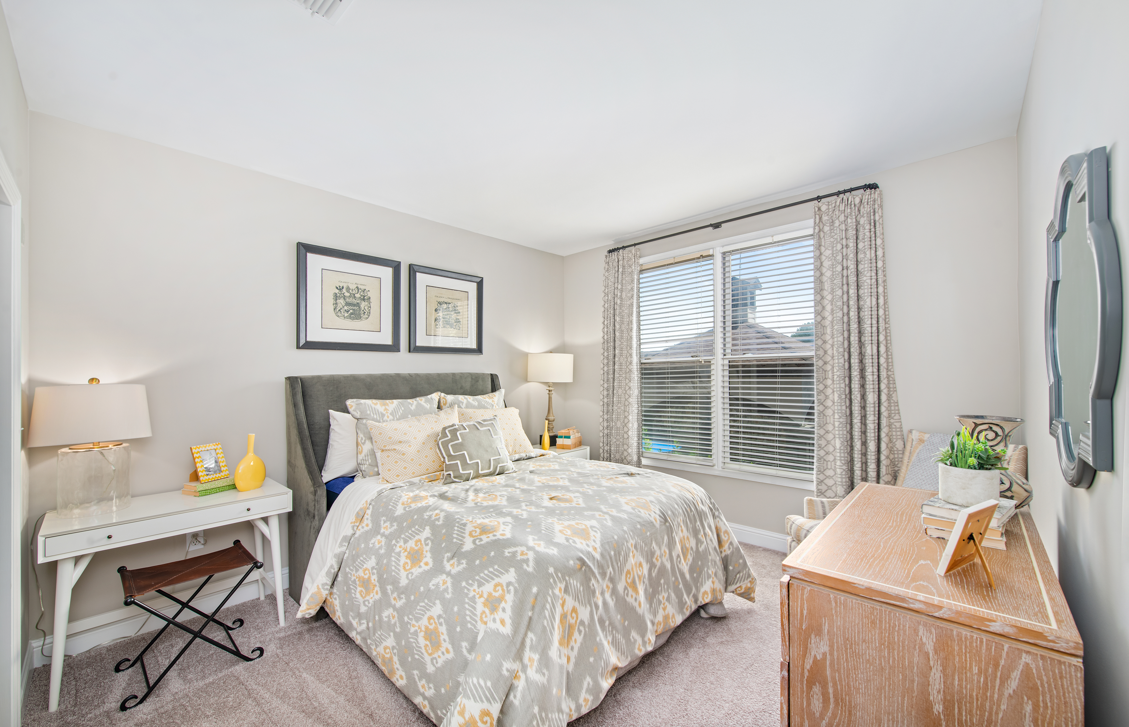 Cozy bedroom with night stands, full-size bed and tan dresser at MAA West Village luxury apartments in Smyrna, GA