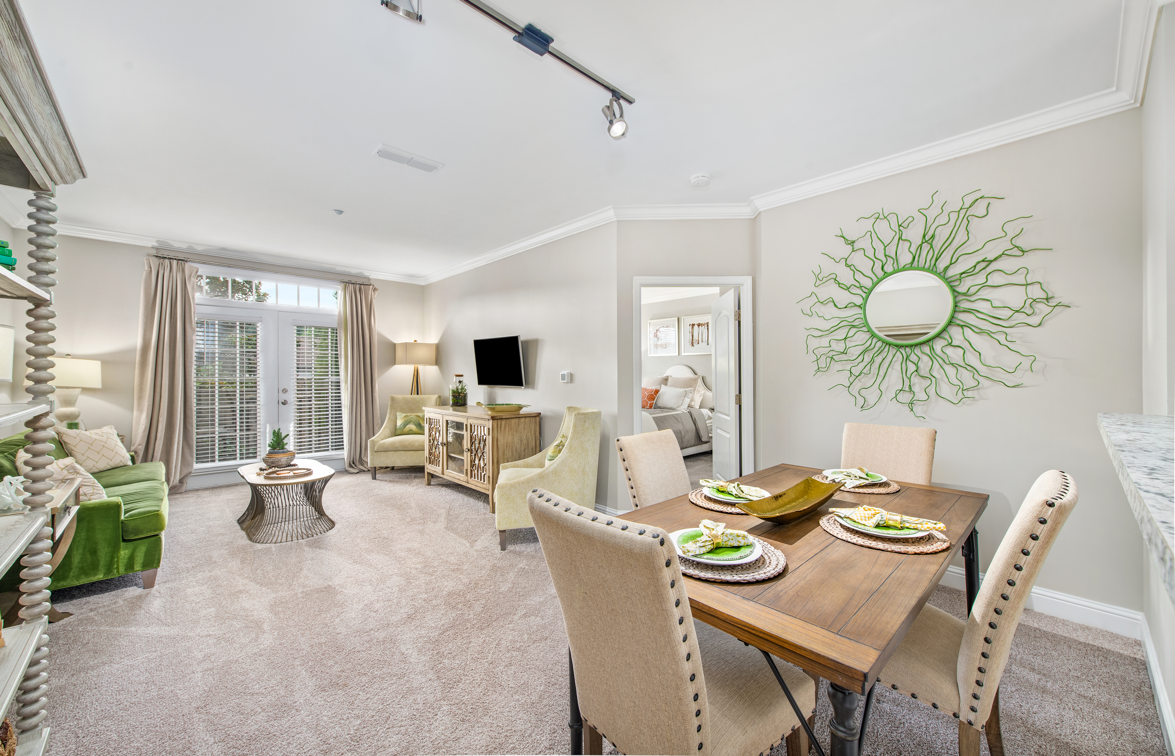 Dining area with dining table and chairs next to living space at MAA West Village luxury apartments in Smyrna, GA