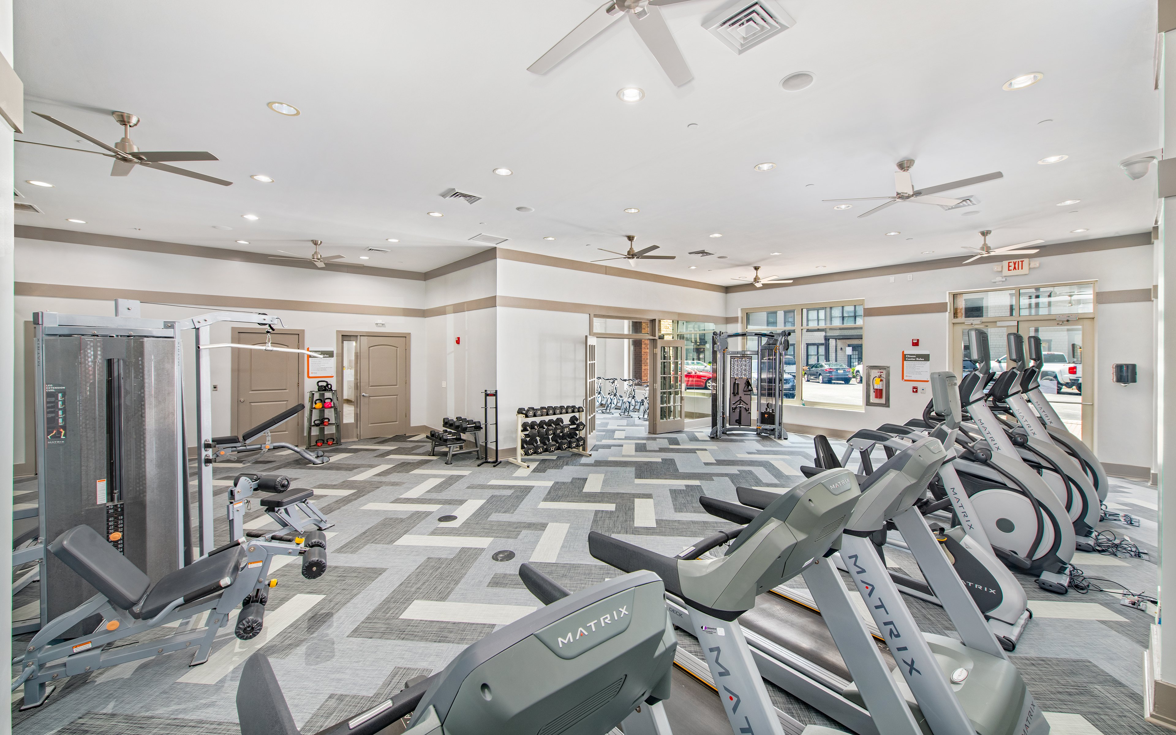 Fitness center with treadmills, weight machines and wall mounted TV at MAA West Village luxury apartments in Smyrna, GA