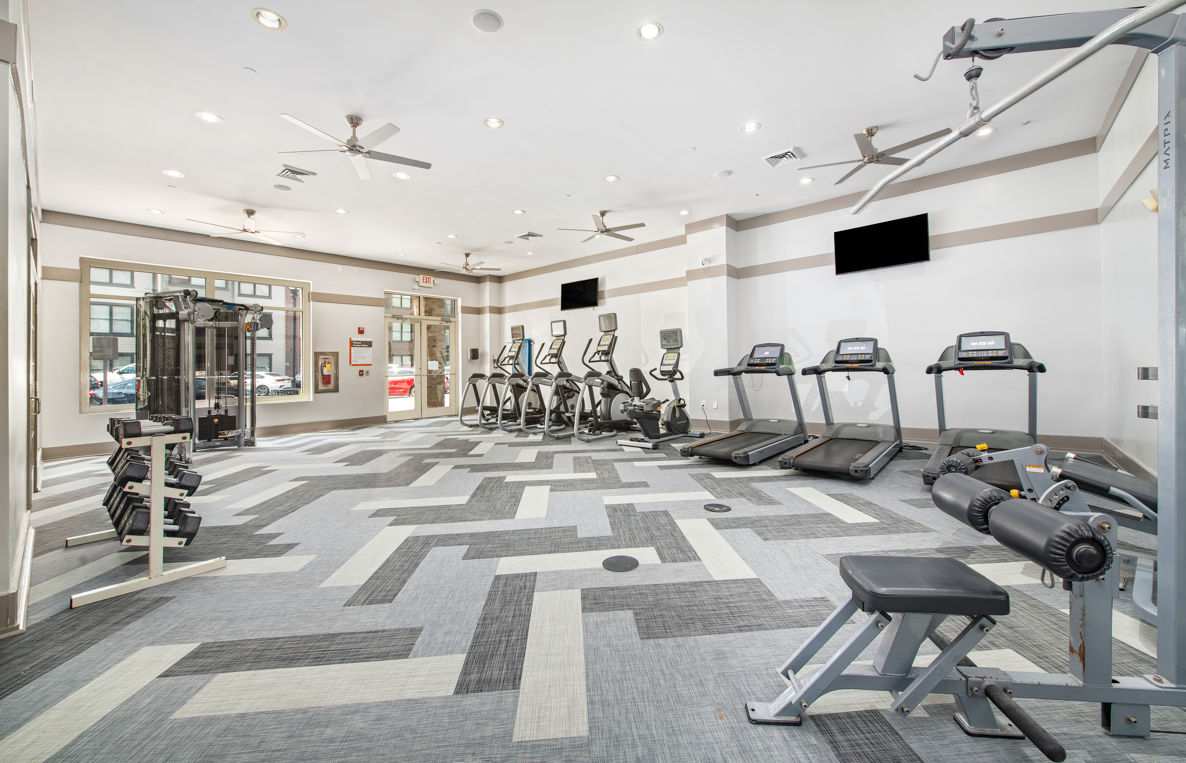 Fitness center with treadmills, free weights and wall mounted TVs at MAA West Village luxury apartments in Smyrna, GA
