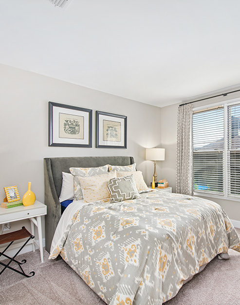 Cozy model bedroom with white night stands and full-size bed at MAA West Village luxury apartments in Smyrna, GA