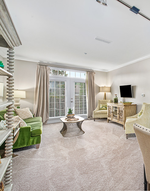 Open living room space with green couch and natural lighting at MAA West Village luxury apartments in Smyrna, GA