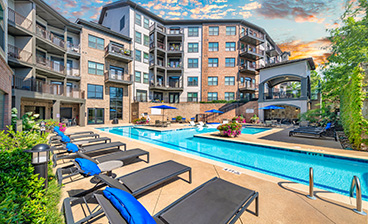 Side view of swimming pool with blue lounge chairs at MAA West Village luxury apartments in Smyrna, GA