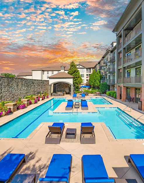 Swimming pool with padded blue lounge chairs at MAA West Village luxury apartments in Smyrna, GA