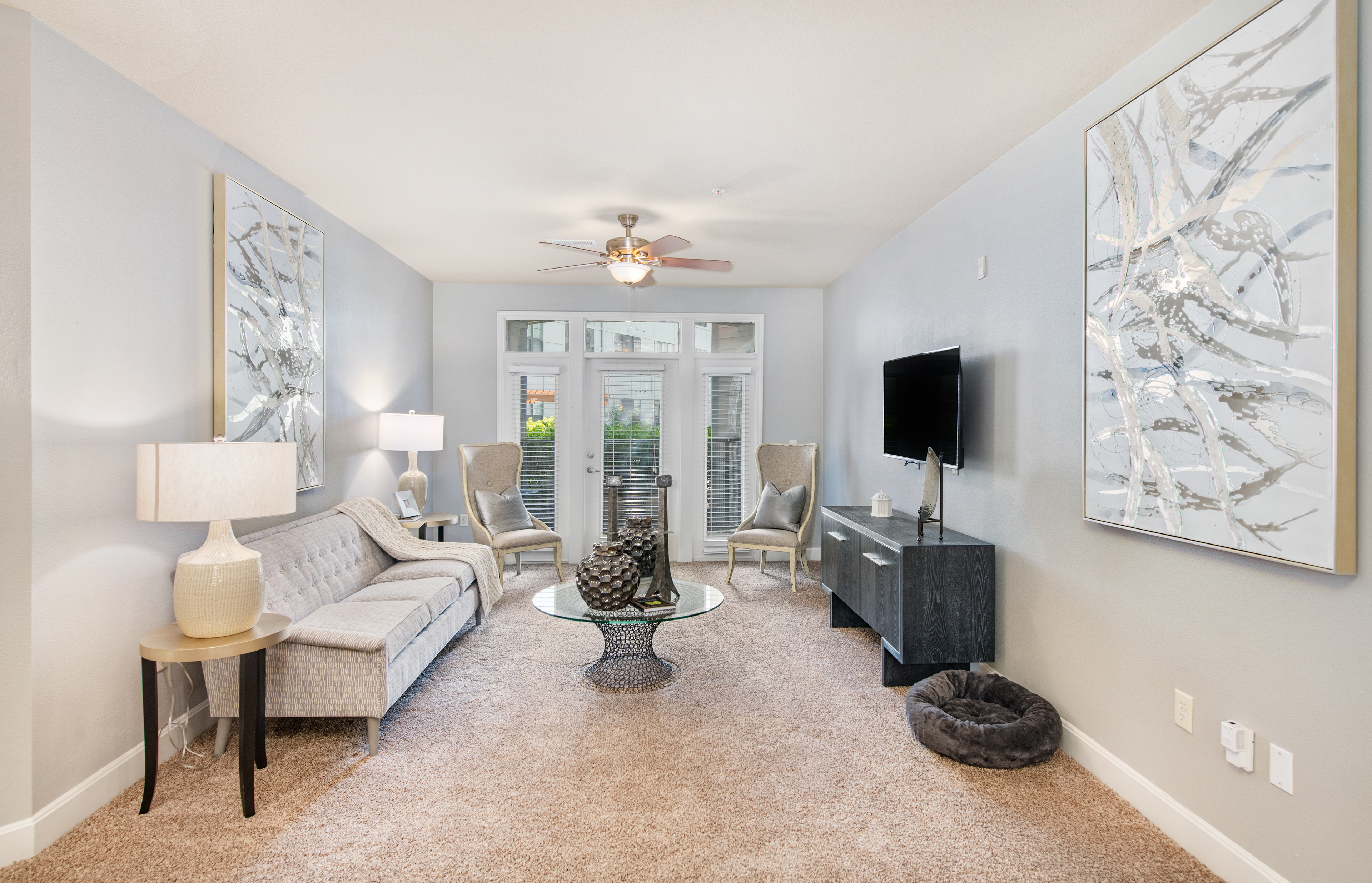 Spacious modern style living room with French doors to patio area at MAA The Station luxury apartments in Kansas City, MO