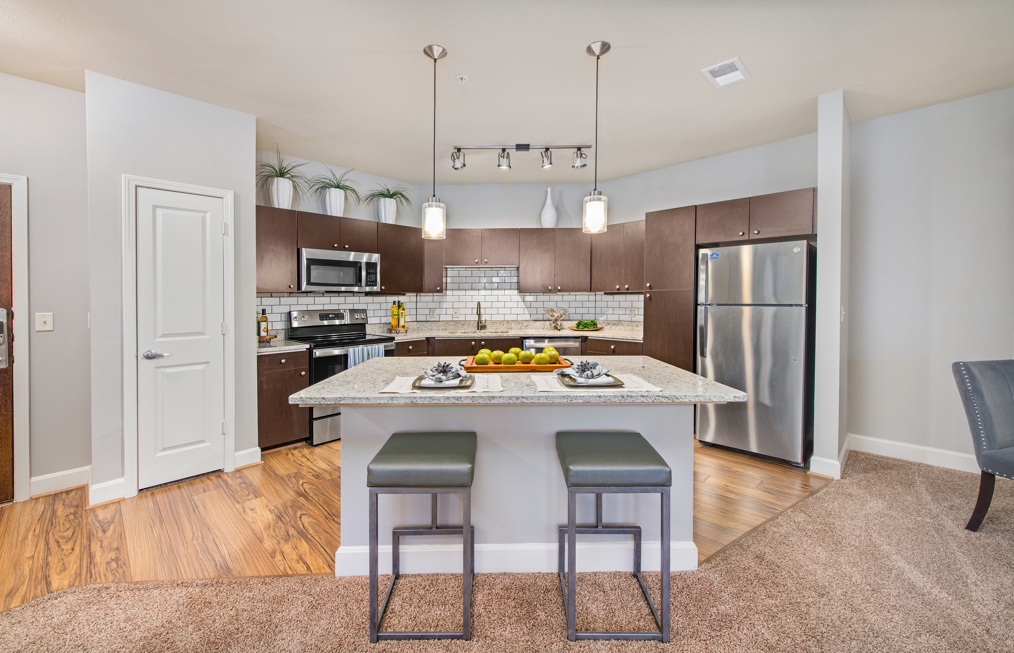 Upscale modern-style kitchen with island and open floorplan dining area at MAA The Station luxury apartments in Kansas City, MO