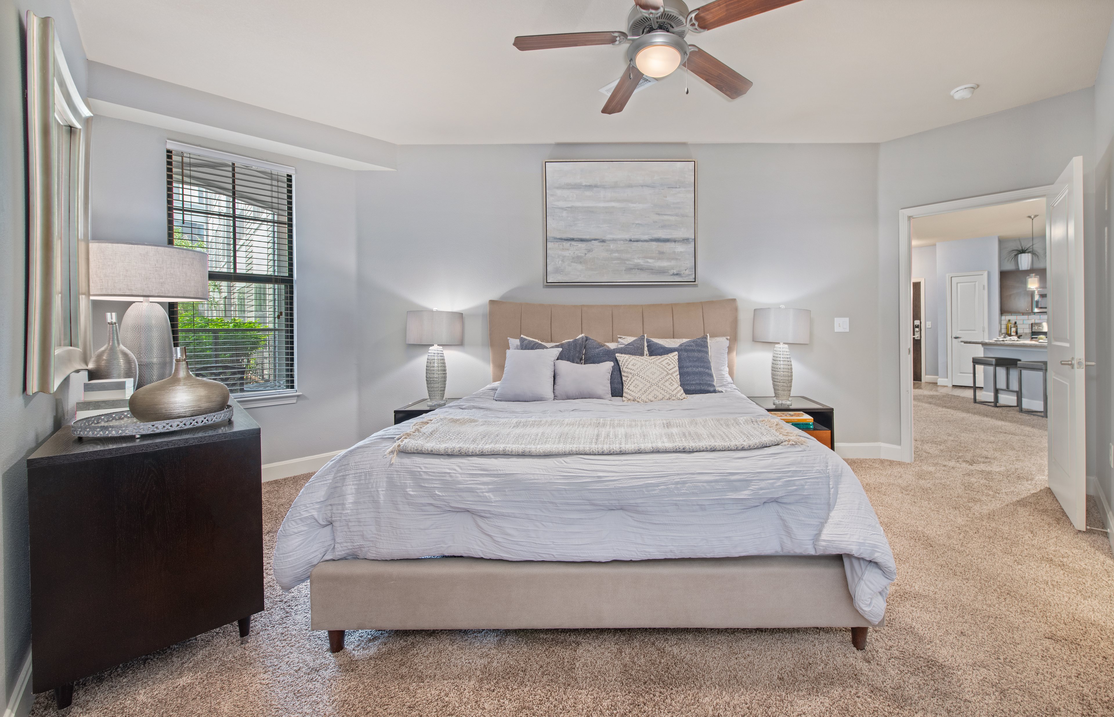 Spacious bedroom with natural lighting and modern-style furniture at MAA The Station luxury apartments in Kansas City, MO