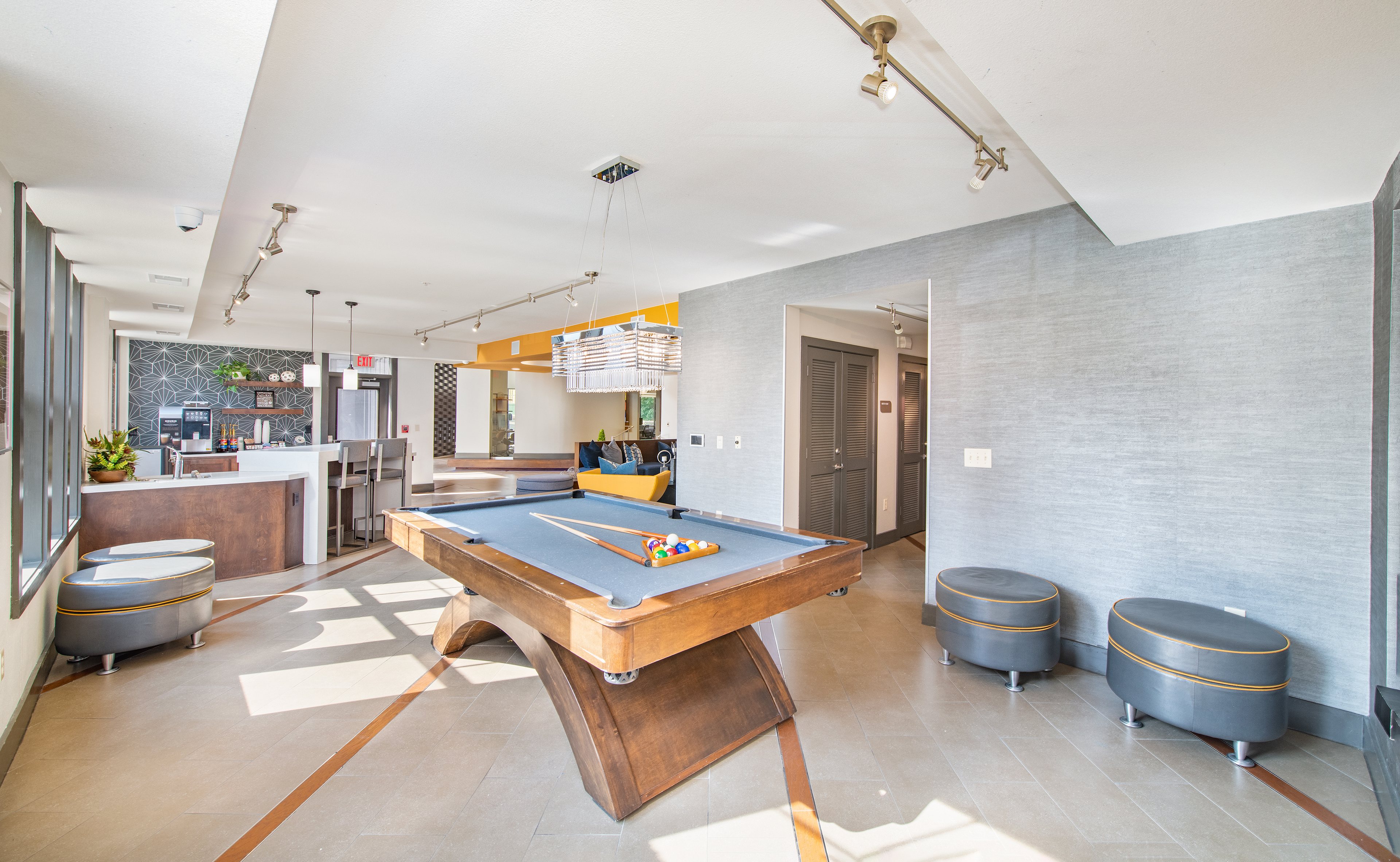 Clubhouse recreation area with billiards table, seating area and kitchen at MAA The Station luxury apartments in Kansas City, MO