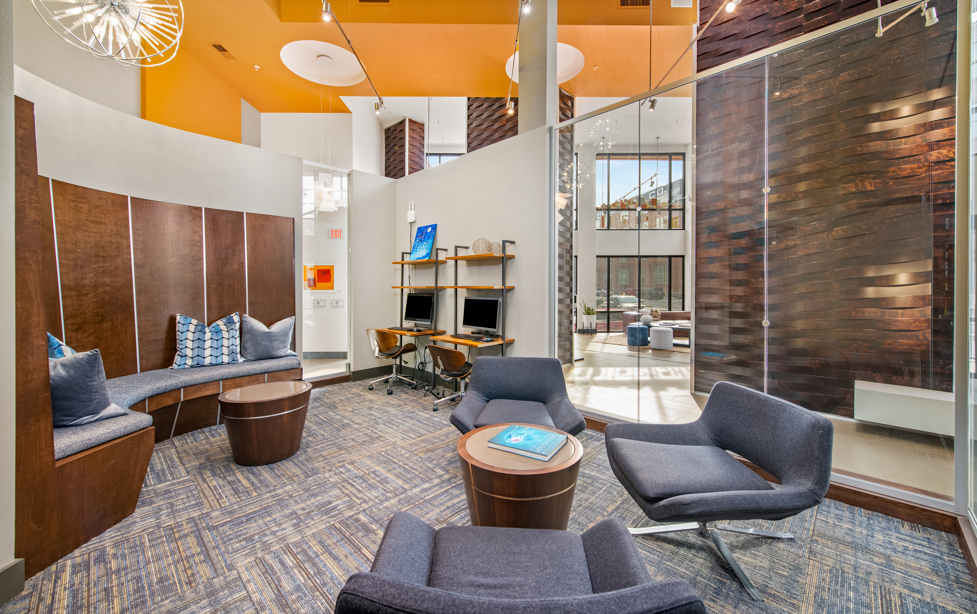 Business center with work stations and lounge seating area with tables at MAA The Station luxury apartments in Kansas City, MO
