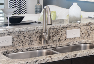 Close view of kitchen granite counter bar top with stainless steel double sink at MAA 1225 luxury apartments in Charlotte, NC