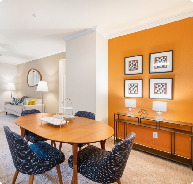 Community clubhouse with orange accent wall with wall art and multiple sitting areas at MAA Beverly Crest luxury apartments in Charlotte, NC