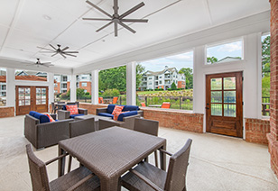 Modern-style clubhouse lanai with multiple sitting areas, ceiling fans and open views at MAA Beverly Crest luxury apartments in Charlotte, NC