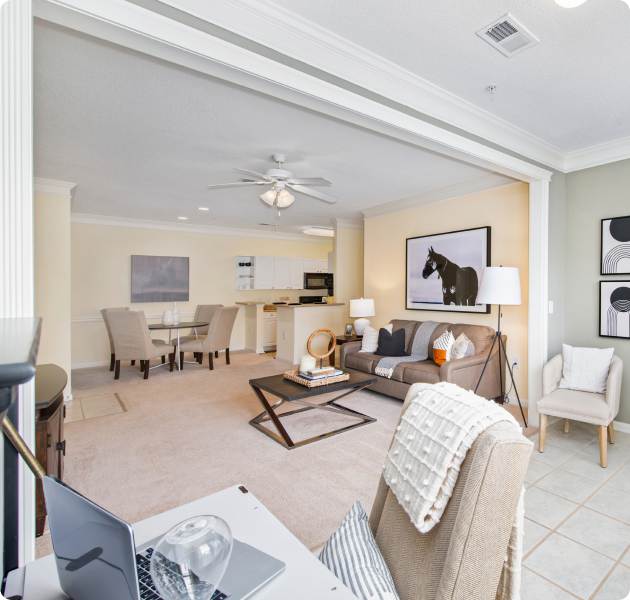 Apartment with large open space living room with crown molding and ceiling fan next to dining area at MAA City Grand luxury apartments in Charlotte, NC