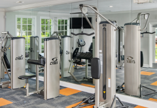 Modern fitness center with weight machines next to a mirrored wall at MAA City Grand luxury apartments in Charlotte, NC