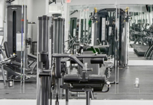 Fitness center with variety of workout equipment next to mirrored wall at MAA Cornelius luxury apartments in Cornelius, NC