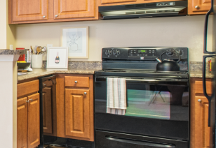 Kitchen with brown cabinets and upgraded appliances at MAA Fifty-One luxury apartments in Matthews, NC