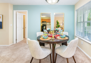 Living room next to dining area with brown round table and wall paintings at MAA Fifty-One luxury apartments in Matthews, NC
