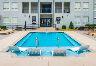 Side view of pool with entrance steps, metal handrails and sundeck loungers situated in center of the apartment complex courtyard area at MAA Gateway luxury apartments in Charlotte, NC