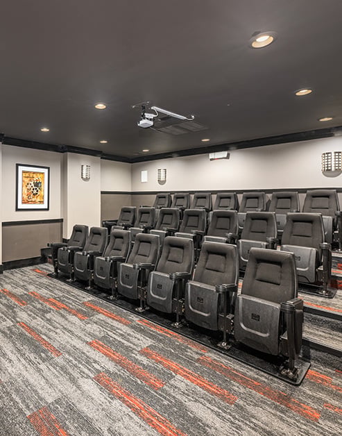 Movie theater room with fold-down theater seats and carpet floorings at MAA Legacy Park luxury apartments in Charlotte, NC
